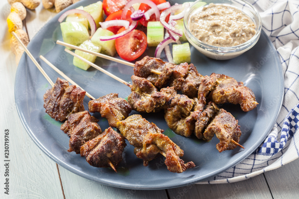 Traditional pork satay with peanut sauce and vegetables