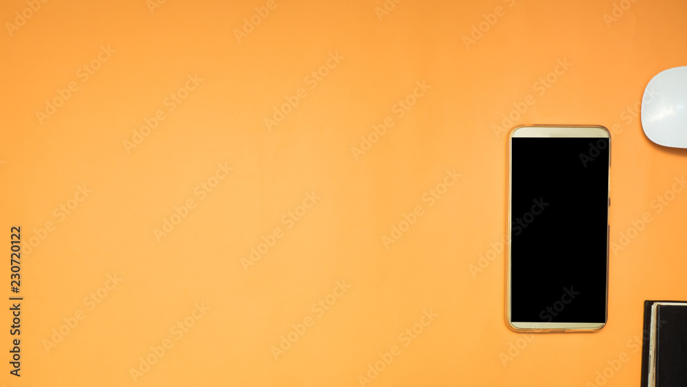 smartphone and notebook on orange background business concept smartphone and notebook on orange background business concept