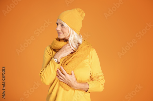 Senior woman posing in cap and scarf. © neonshot