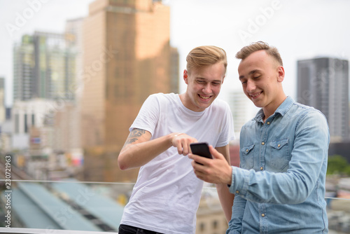 Photography Young happy man couple using mobile phone outdoors