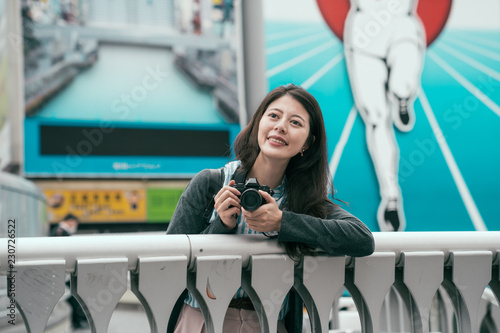 young lady relaxing on the bridge with camera photo