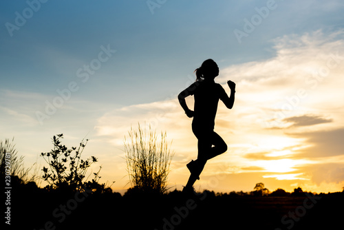 silhouette woman running alone at beautiful sunset in the park.