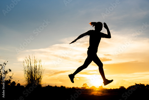 silhouette woman running alone at beautiful sunset in the park.