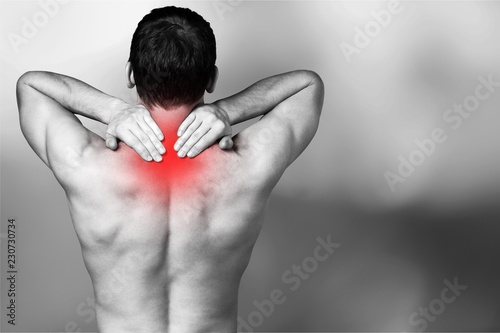Strong man with neck pain, back view