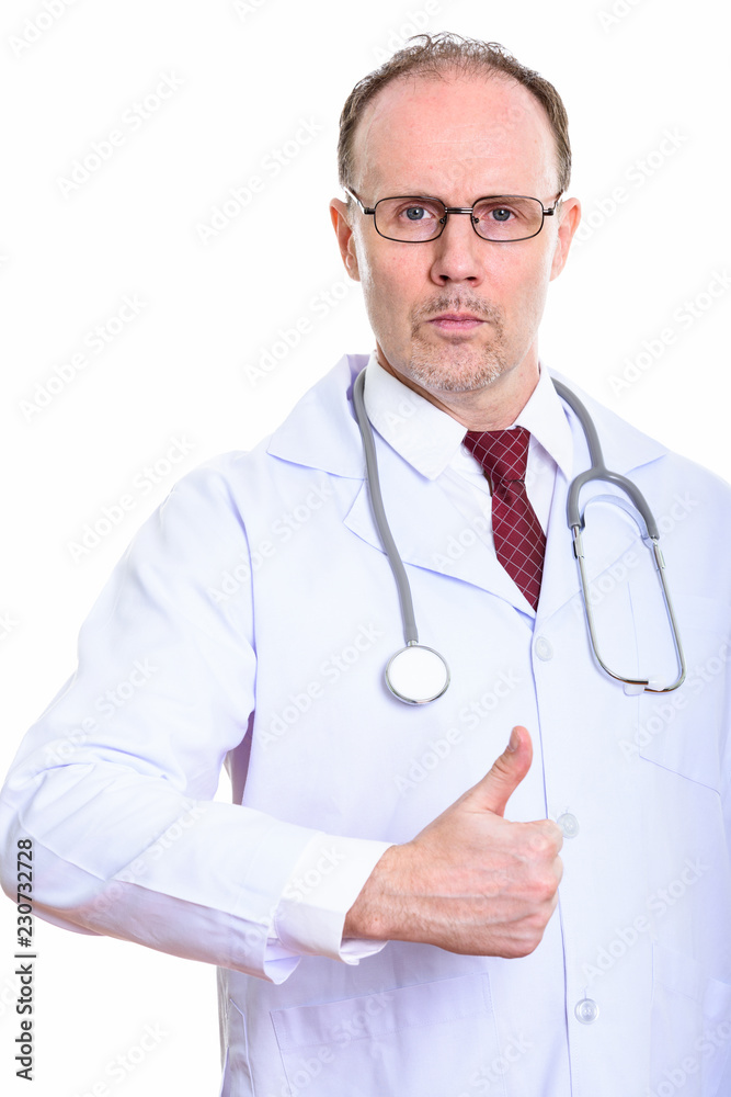 Studio shot of mature man doctor giving thumb up Studio shot of mature man doctor giving thumb up