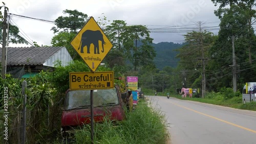 Yellow elephant warning sign at the side of the road in Thailand. ZOOM OUT