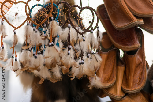 white feather amulets and national Slippers hanging on the market for sale