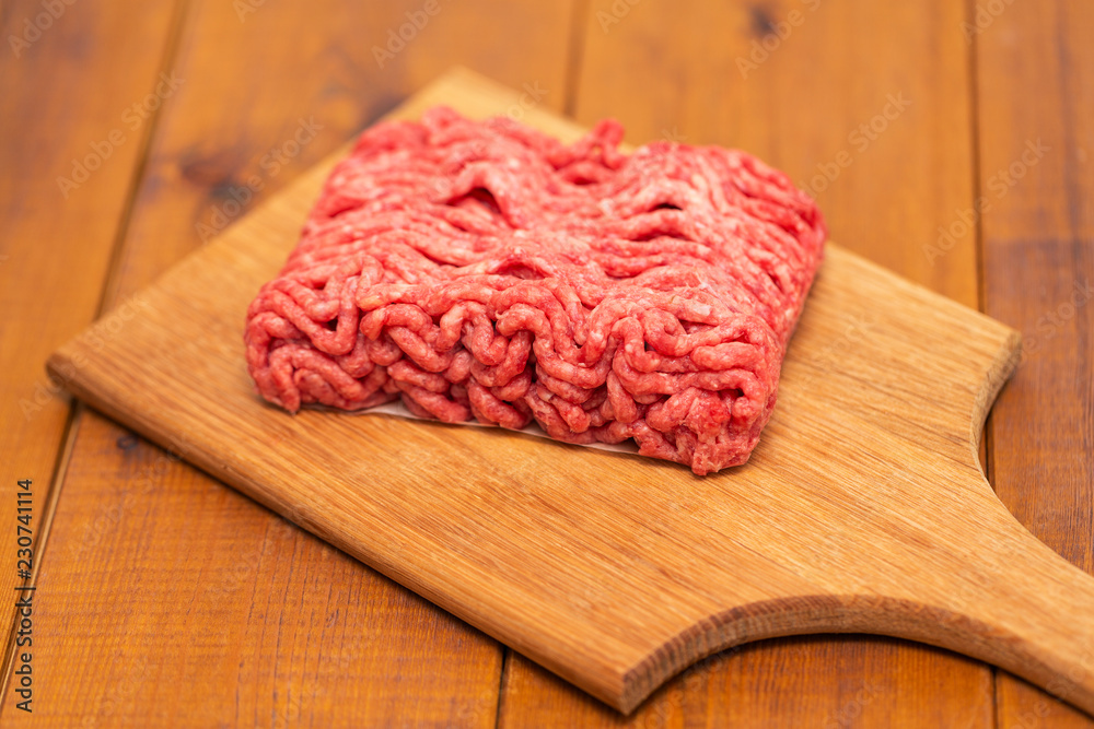 Portion of Minced Meat on an wooden table 