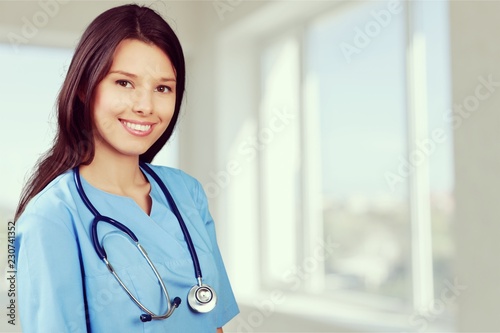 Portrait of young cute woman doctor on background