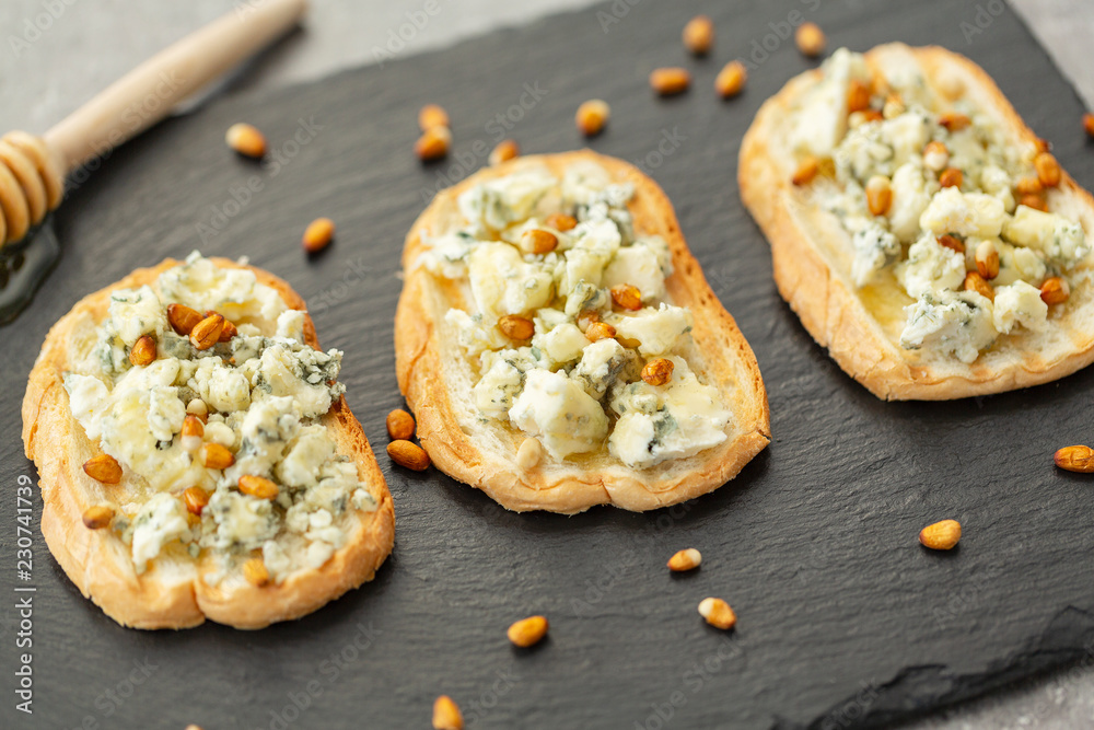 Sandwich, grilled baguette with blue cheese, honey and pine nuts Sandwich, grilled baguette with blue cheese, honey and pine nuts