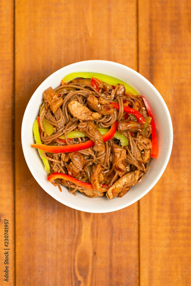 Noodles with pork, vegetables and sesame. On a wooden table. Noodles with pork, vegetables and sesame. On a wooden table.