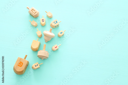 Image of jewish holiday Hanukkah with wooden dreidels colection (spinning top) over mint background.