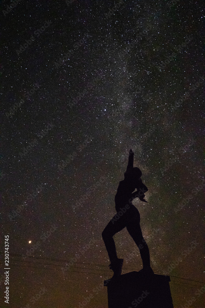 Silhouette of powerful woman in front of the Milky Way Galaxy