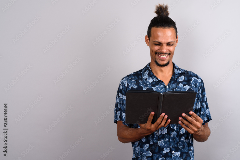 Young bearded handsome African man against gray background Young bearded handsome African man against gray background