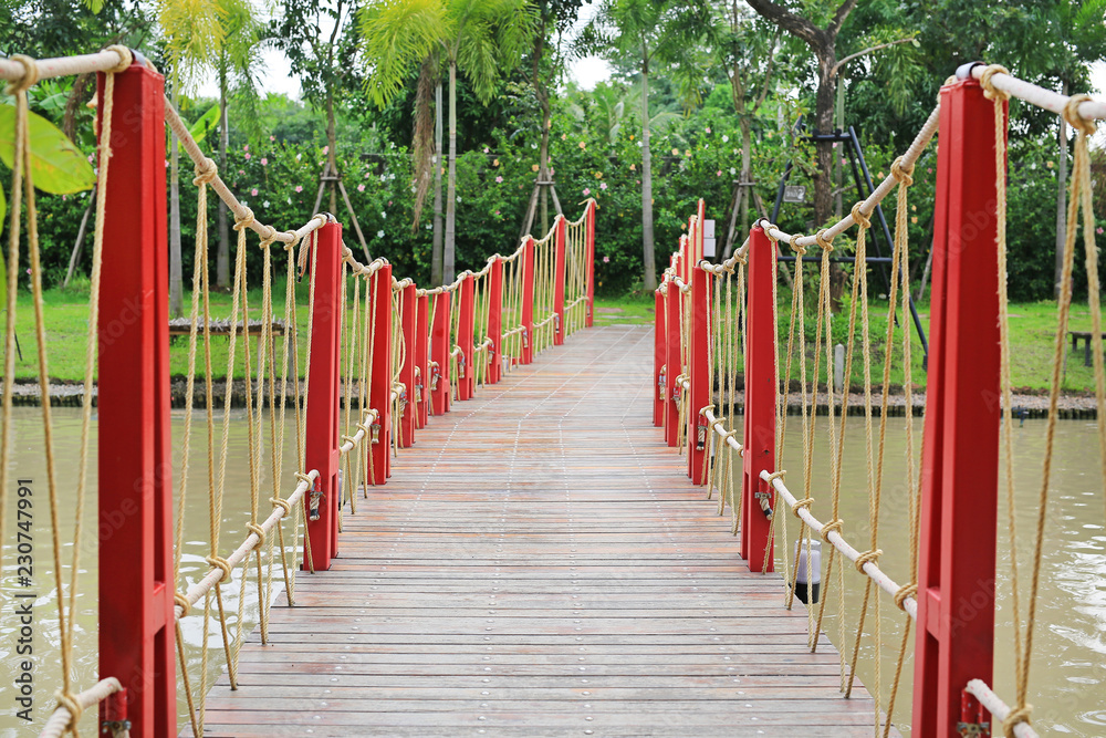 Adventure wooden rope suspension bridge crossing river. Adventure wooden rope suspension bridge crossing river.