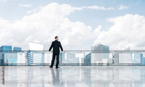 Sunrise above skyscrapers and businessman facing new day