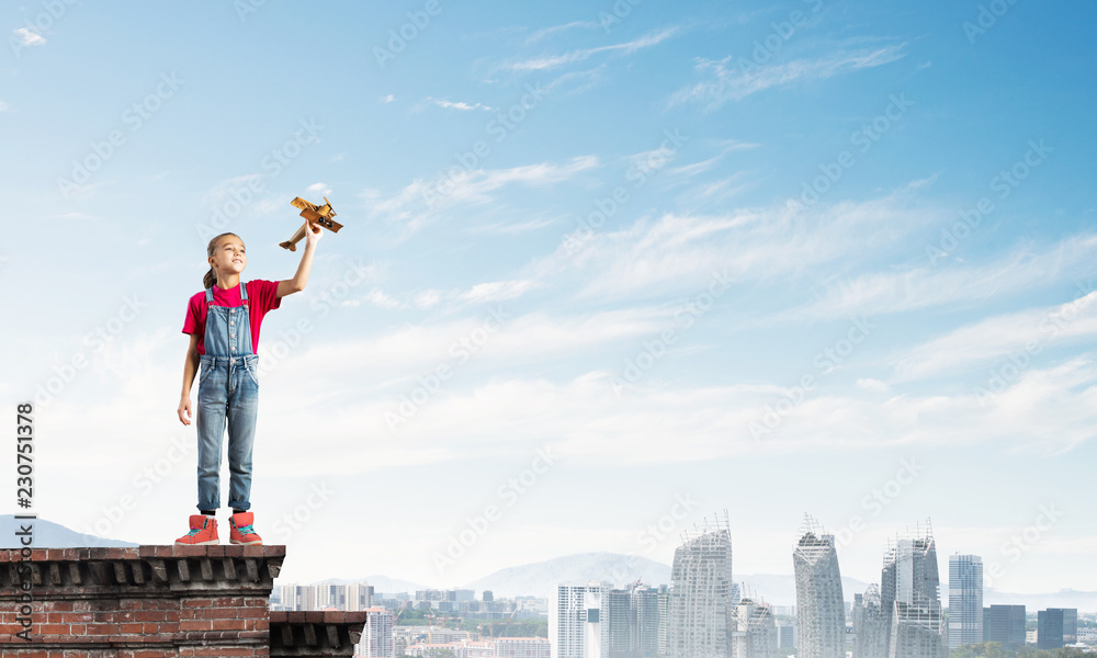 Concept of careless happy childhood with girl dreaming to become pilot Concept of careless happy childhood with girl dreaming to become pilot