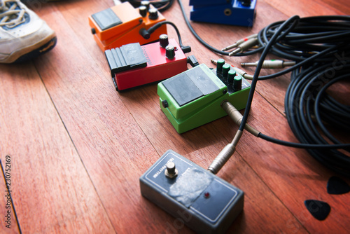 Electric guitar audio processing effects  on a studio floor. Stomp box type effectors and cables on studio floor. photo