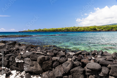 View of kealakekua bay on Hawaii's Big Island, looking from Puuhonua Historical Park. Crystal blue-green water in the bay; coastline in the background, black Volcanic rock in foreground. photo