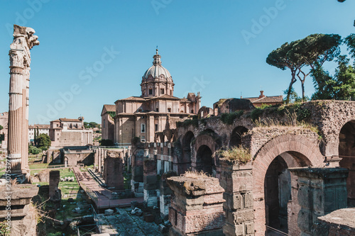 View of Roman Forum with the Temple of Saturn, Rome, Italy. Roman Forum is one of the main travel destinations in Europe. Beautiful panorama of Roman Forum in summer. Ancient ruins in central Roma.