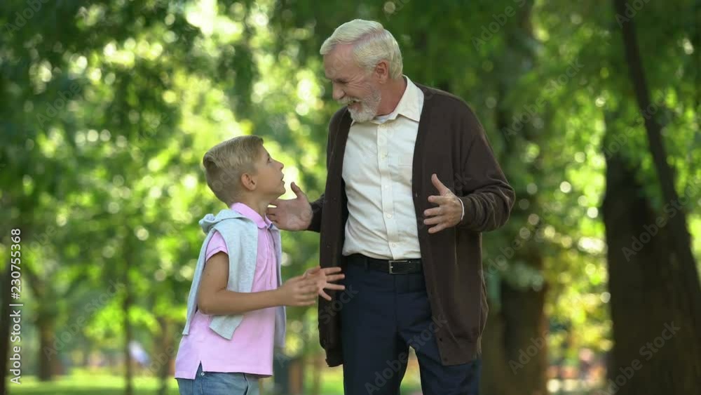 Excited boy tells impressions to granddad, confidential conversation, friendship Excited boy tells impressions to granddad, confidential conversation, friendship