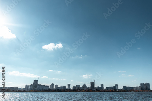 Cityscape, view from the river, blue sky.