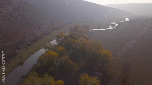 Beautiful sunrisw over river in rural area. Fog over small river. Mountains landscape. photo