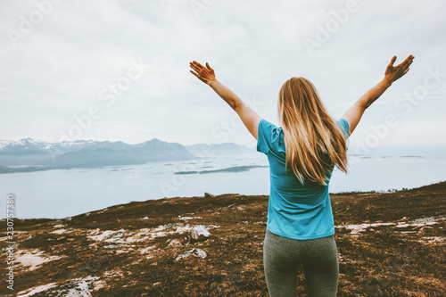 Happy woman raised arms traveling in Norway hiker on the top of mountain healthy lifestyle adventure vacations outdoor success joyful emotions girl