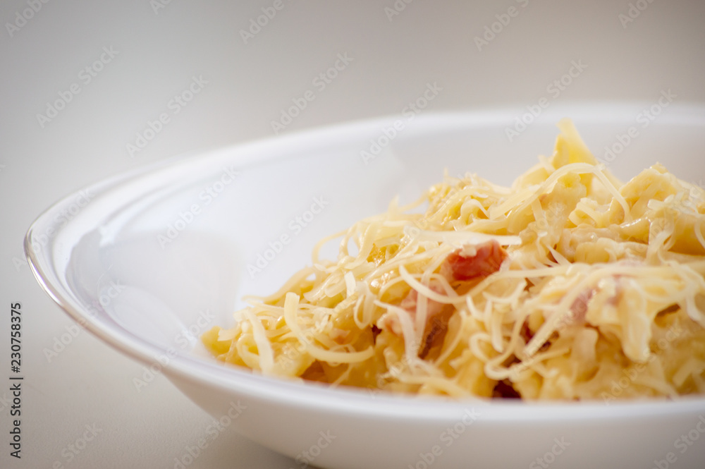Macaroni carbonara presented on a white dish Macaroni carbonara presented on a white dish