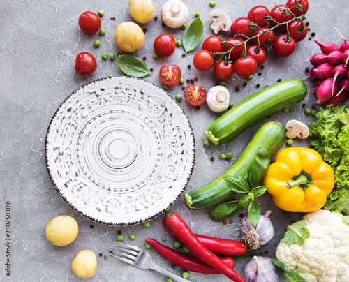 Empty plate and fresh vegetables photo