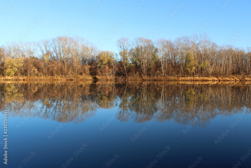 Autumn landscape with reflection of trees in the river