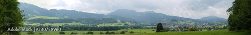 Ultra wide panorama of Bavarian Mountain landscape with field, clouds and forest