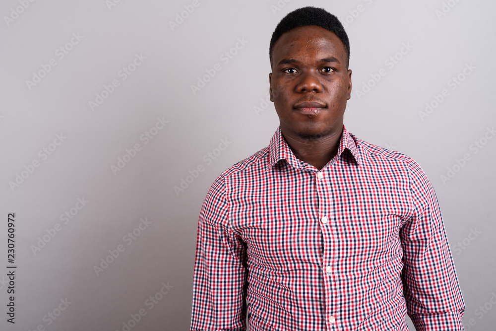 Obraz premium Young African businessman standing against white background