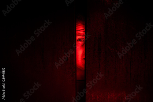 Фотография Agoraphobia concept / eye peeking behind the door