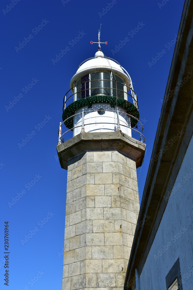 Old white lighthouse with wind vane. Blue sky, Galicia, Spain. Old white lighthouse with wind vane. Blue sky, Galicia, Spain.