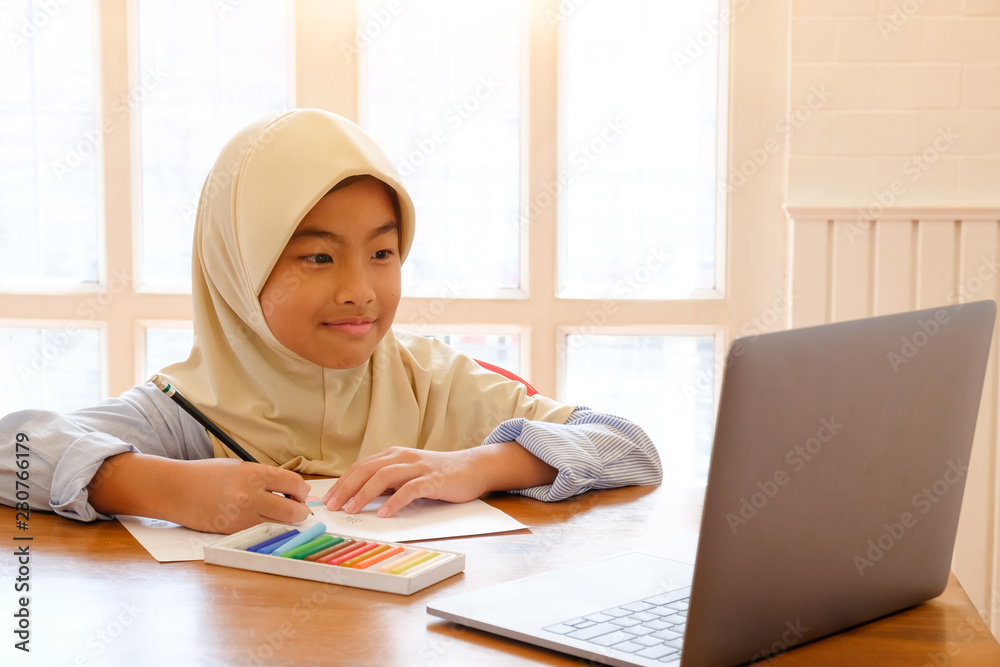 Muslim education concept, Children drawing with pencil and colour on paper with laptop. Muslim education concept, Children drawing with pencil and colour on paper with laptop.