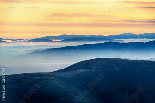 Wonderful morning high in the mountains with clouds below the mountain tops in the valleys. © Mny-Jhee