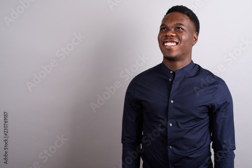 Portrait of young African businessman against white background