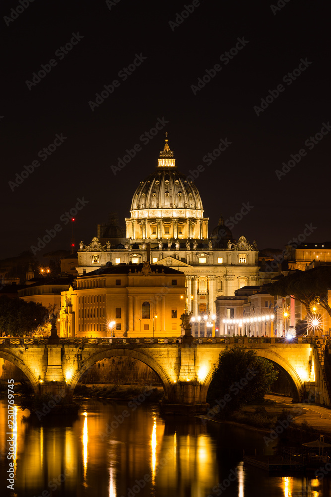Illuminated St. Peter's Basilica and reflections in the Tiber River after sunset in Rome, Italy