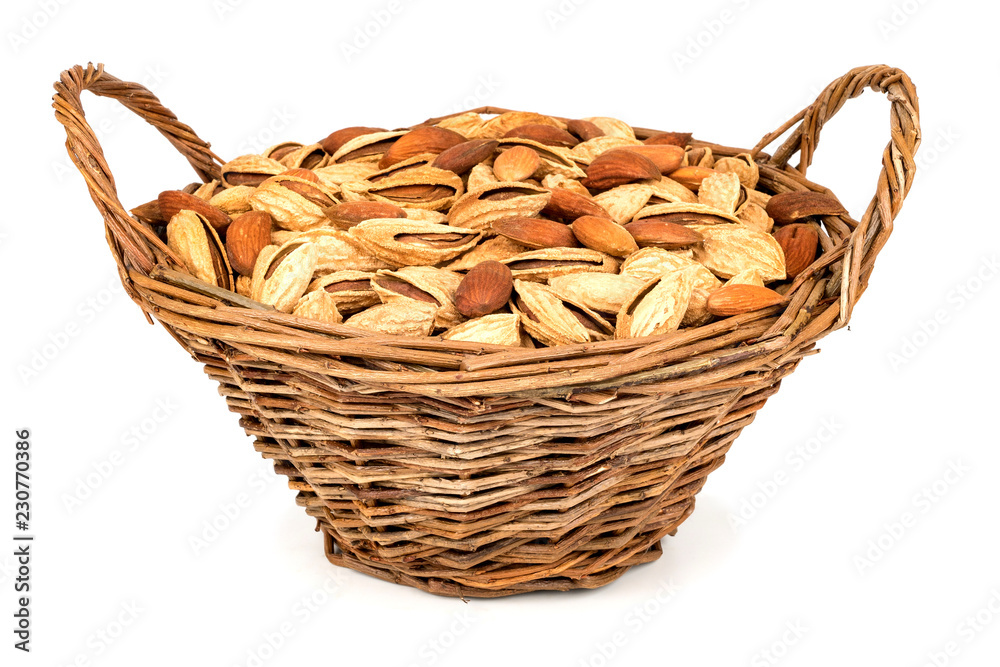 Wicker basket full of almond nuts isolated over the white background.