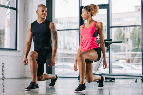 selective focus of young african american couple of athletes exercising at gym