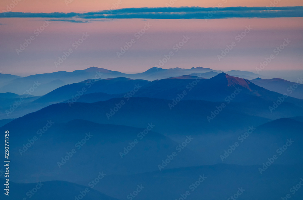 Beautiful morning alpine landscape with tonal perspective. Ponk and blue tonality mountains with foggy valleys