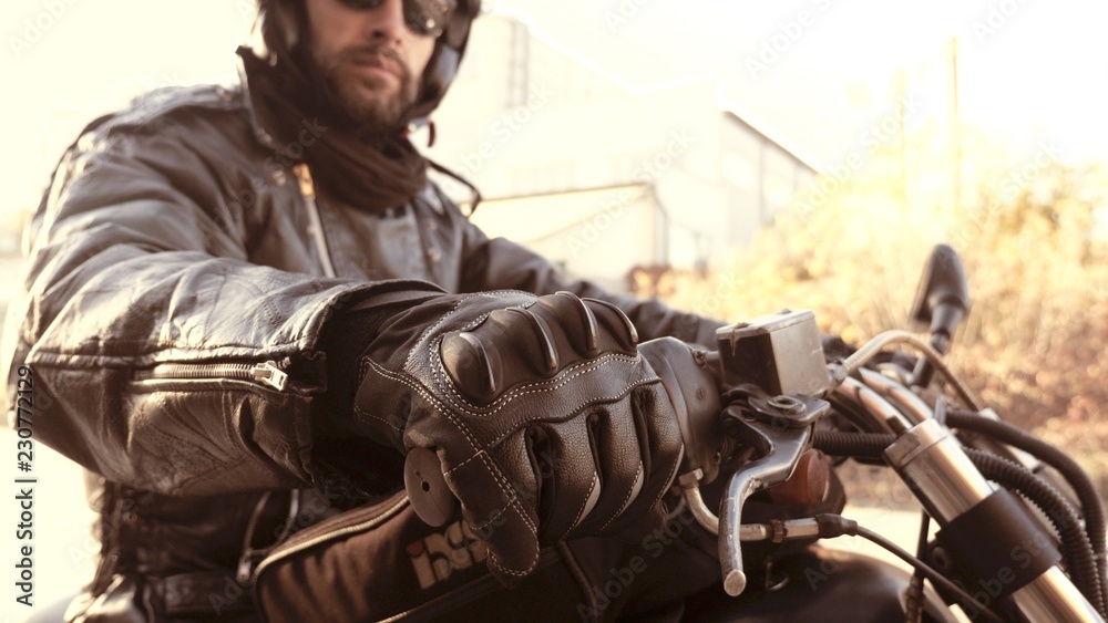 Fototapeta premium Motocyklista w skórzanych rękawiczkach na rączce gotowy do pracy