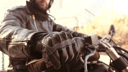 Motorbike person in leather gloves on start handle ready to go