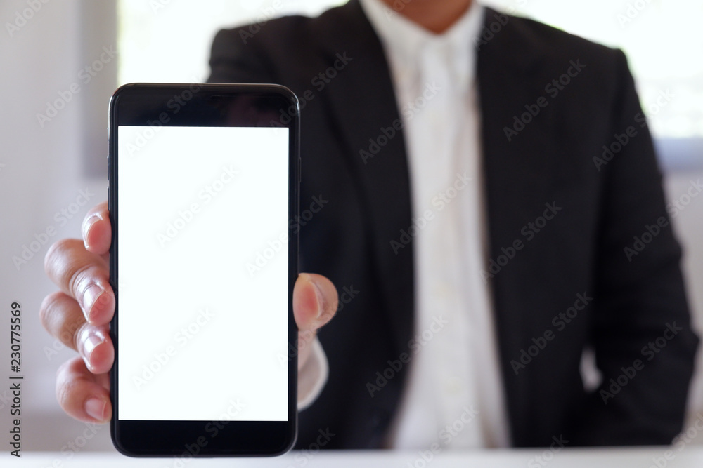 Businessman holding smartphone forward empty white screen for your text or picture. Businessman holding smartphone forward empty white screen for your text or picture.