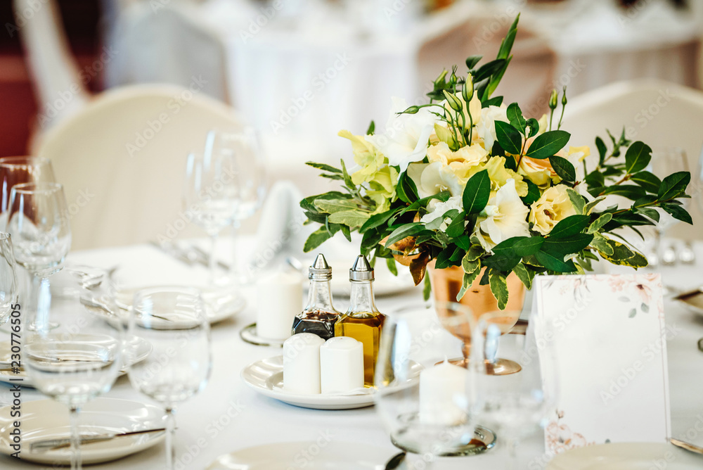 Fototapeta premium Wedding table set up. Indoor set up of a wedding/party table with flower decoration