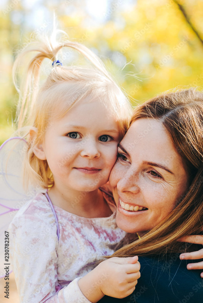 Mother and little daughter playing together in a park Mother and little daughter playing together in a park