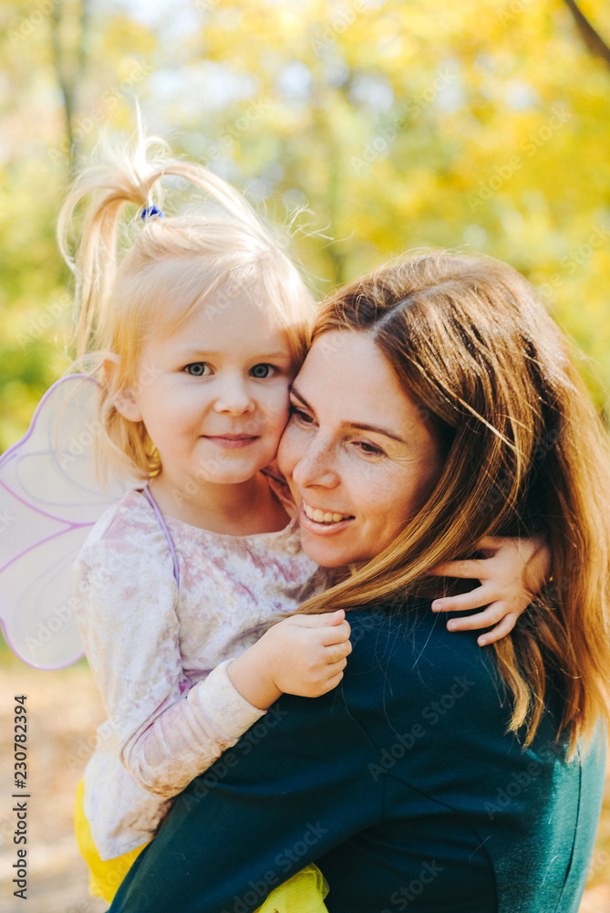 Mother and little daughter playing together in a park Mother and little daughter playing together in a park