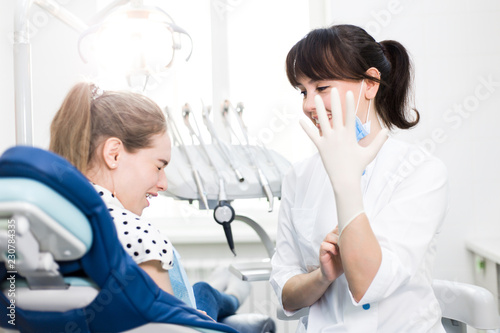 Dentist treats the teeth of the patient sitting in the dental chair