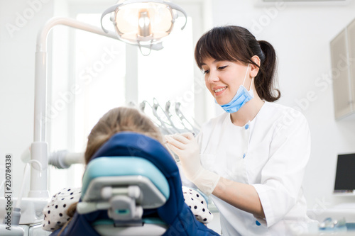 Dentist treats the teeth of a patient sitting in a dental chair in a modern clinical hospital